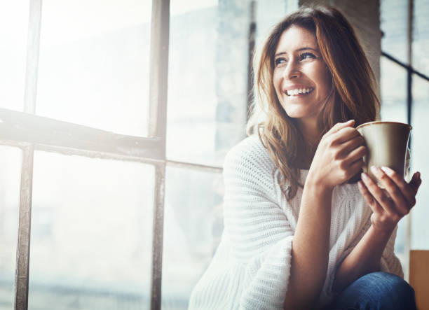 Person enjoying peaceful tea time by window with natural light